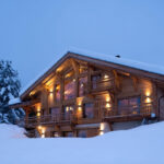 Ambiance nuit avec contraste d'un chalet tout illuminé.