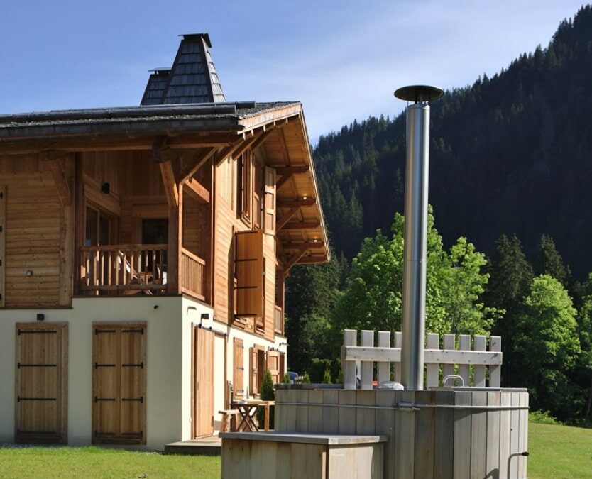 Reconstruction d'un chalet, façade avec crépi et mélèze.