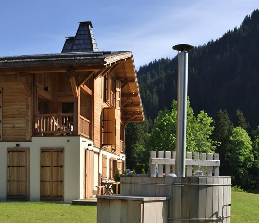 Reconstruction d'un chalet, façade avec crépi et mélèze.