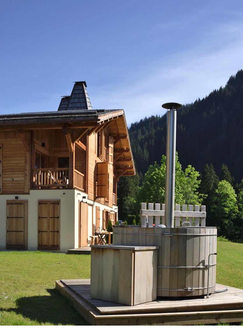 Reconstruction d'un chalet, façade avec crépi et mélèze.