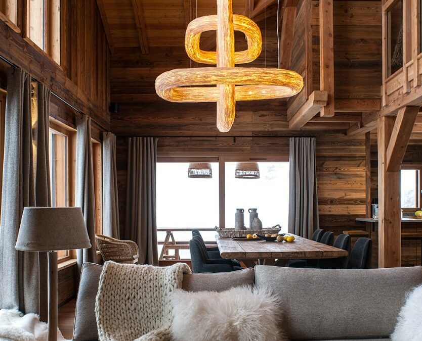 Salon d'un chalet en mélèze avec lustre monumental. Ambiance luxe.