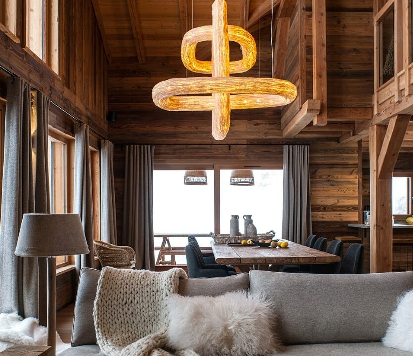 Salon d'un chalet en mélèze avec lustre monumental. Ambiance luxe.